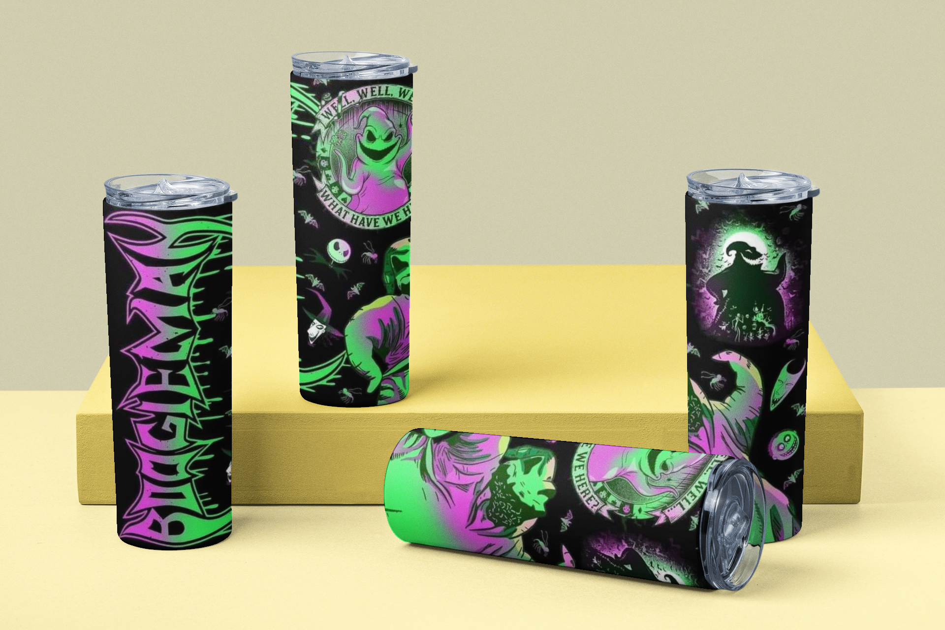Four tumblers with colorful designs on a beige background